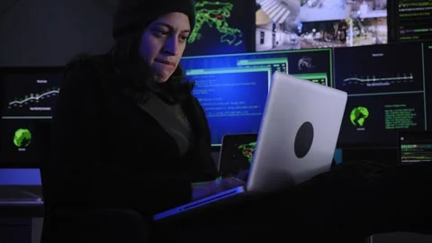 Female criminal hacker excitedly performs a cyber attack in a dark environment Video stock 251489013