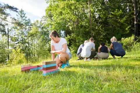 Female Crouching By Building Blocks While Friends Planning On Fi Фото