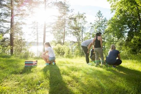 Female Crouching By Building Blocks While Coworkers Planning On Foto stock