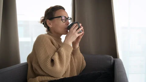 Female with a cup of coffee in a chair Stock Footage 252151753