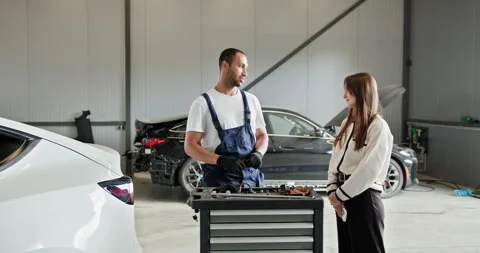 Female Customer Discussing Car Issues With Mechanic in Workshop Stock Footage 276611827