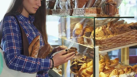 Female customer exploring delicious cookie options at the bakery Stock Footage 311536599