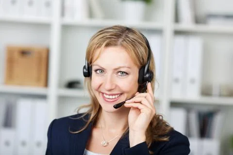 Female customer service operator using headset in office Stock Photos