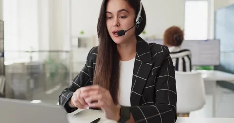Female customer support agent with microphone headset consulting clients in Stock Footage 341423165