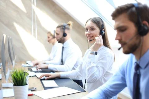 Female customer support operator with headset and smiling. Stock Photos
