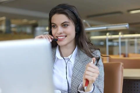 Female customer support operator with headset and smiling. Stock Photos