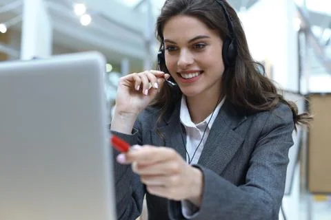 Female customer support operator with headset and smiling. Stock Photos