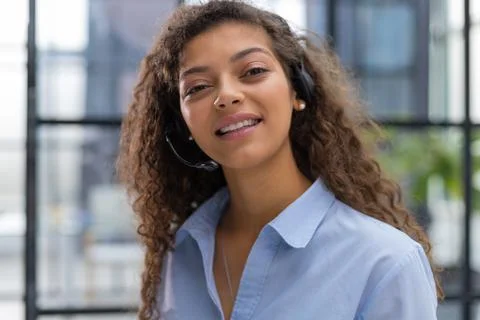 Female customer support operator with headset and smiling. Stock Photos