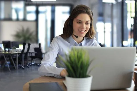 Female customer support operator with headset and smiling. Stock Photos