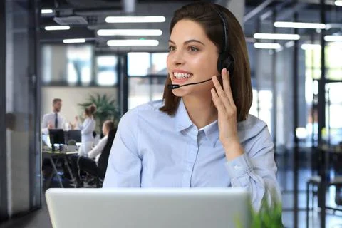 Female customer support operator with headset and smiling. Stock Photos