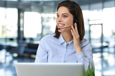 Female customer support operator with headset and smiling. Stock Photos