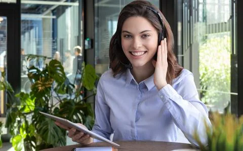 Female customer support operator with headset and smiling. Stockfoto's