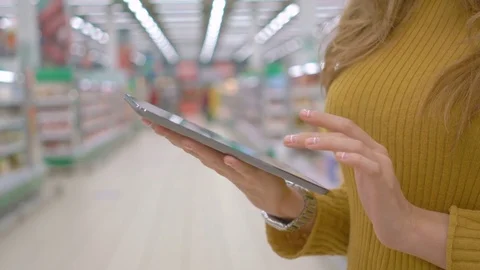 Female customer using a digital tablet at supermarket Stock Footage 75276308