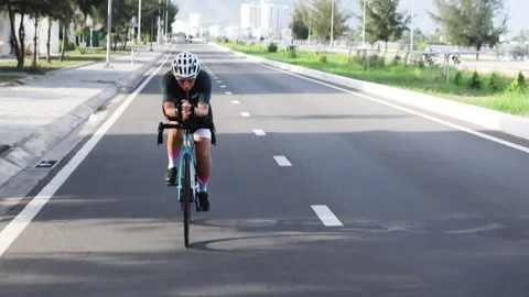 Female cyclist pushes her limits on sunny day along smooth track. Stock Footage 286188746