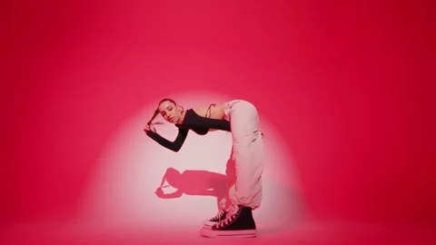 Female dancer dancing on red color wall round with white spot light background Stock Footage 276136012