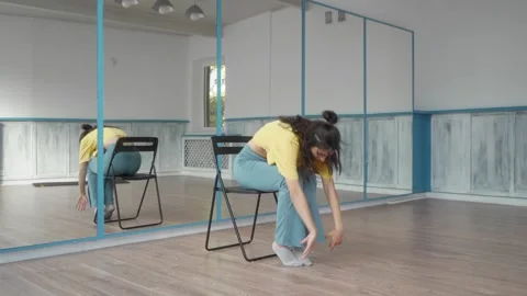 Female dancer performing a contemporary dance routine while seated on a chair. Stock Footage 287099652