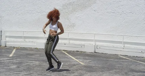 Female dancer performing her routine on top of a parking garage Stock Footage 97026497