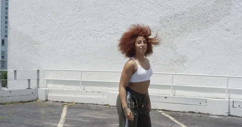 Female dancer performing her routine on top of a parking garage Stock Footage 97028241