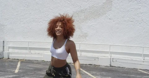 Female dancer performing her routine on top of a parking garage Stock Footage 97035013