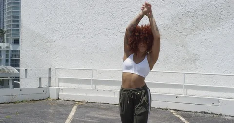 Female dancer performing her routine on top of a parking garage Stock Footage 97035557