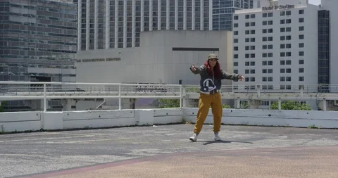 Female dancer performing her routine on top of a parking garage Stock Footage 97037946