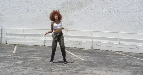 Female dancer performing her routine on top of a parking garage Stock Footage 97038119