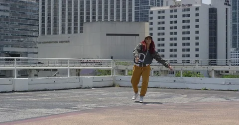 Female dancer performing her routine on top of a parking garage Stock Footage 97239806