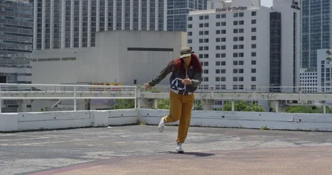 Female dancer performing her routine on top of a parking garage Stock Footage 97243204