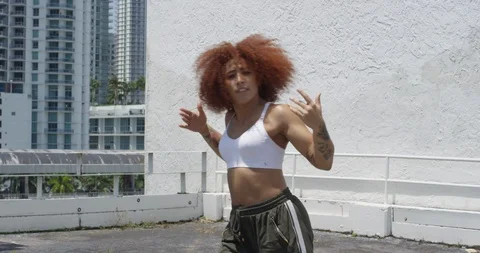Female dancer performing her routine on top of a parking garage Stock Footage 97244781