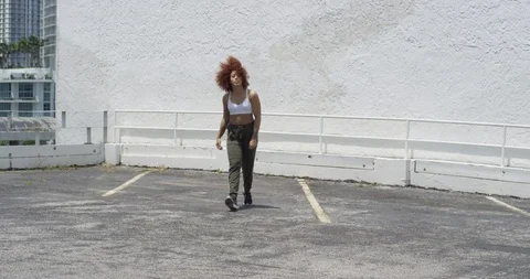 Female dancer performing her routine on top of a parking garage Stock Footage 97389625
