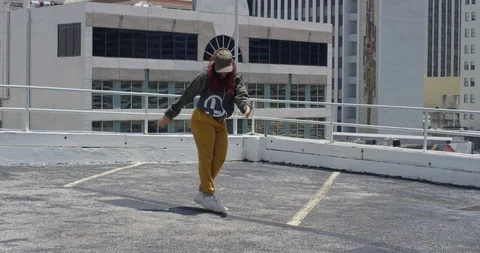 Female dancer performing her routine on top of a parking garage Stock Footage 97450911