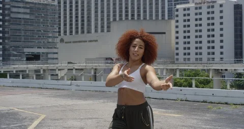 Female dancer performing her routine on top of a parking garage Stock Footage 97451547