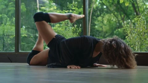 Female dancer performs sensual choreography on studio floor, natural background. Stock Footage 244871669