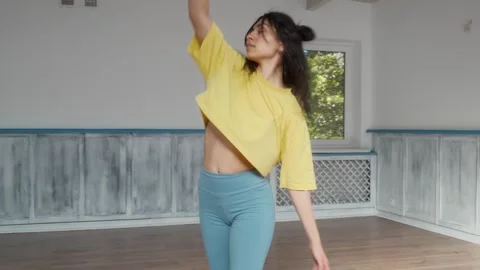 Female dancer performs spins in a studio with mirrors, showing grace and balance Stock Footage 287099343