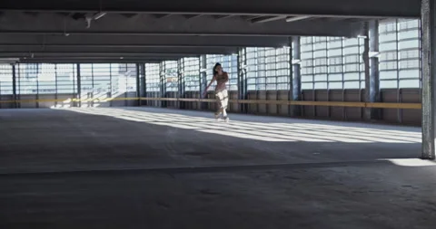 Female dancer walking in spacious indoor parking Stock Footage 213647720