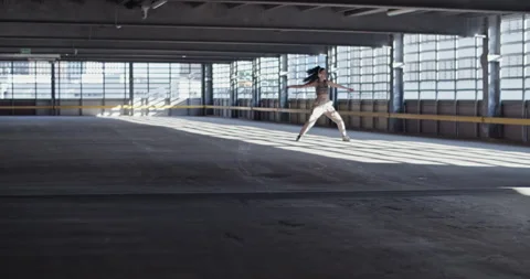 Female dancer walking in spacious indoor parking Stock Footage 213656904