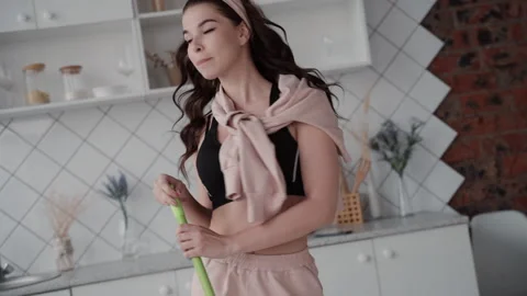Female dancing moving to music while cleaning the house with mop. young woman Stock Footage 133800254