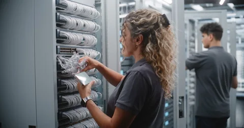 Female Data Center Engineer Verifying Network Ports with Smartphone Stock Footage 344957714