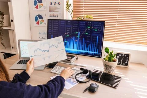 Female data scientist working with computer and diagrams at desk in office Stock Photos