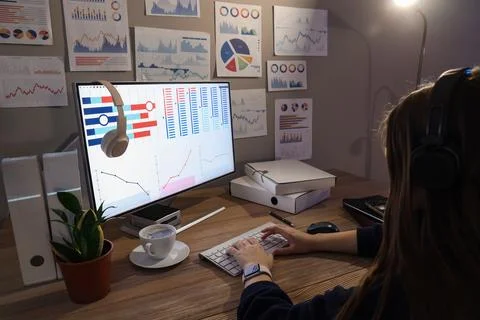 Female data scientist working with computer at desk in dark office 写真素材