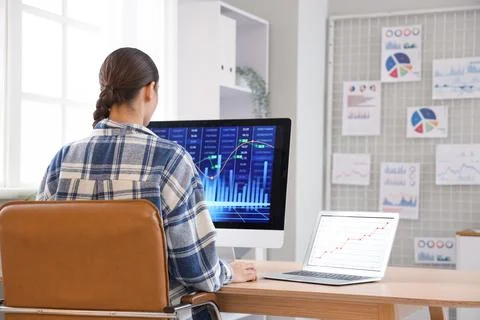 Female data scientist working at desk in office, back view Stock Photos