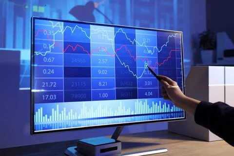 Female data scientist's hand working with computer at desk in dark office 写真素材