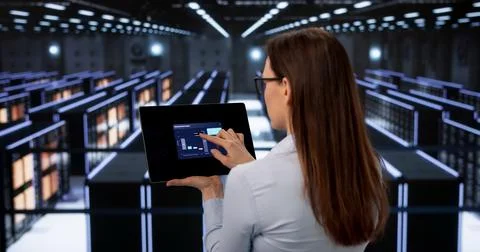 Female Data Technician Performs Thorough Security Checks In Cloud Server Room Foto stock