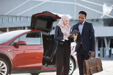 Female dealer using tablet while talking with african man Фото