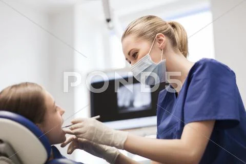 Female Dentist Checking Patient Girl Teeth