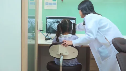 Female dentist explaining teeth x-ray to a little girl in dental clinic, teet Video stock 171317080