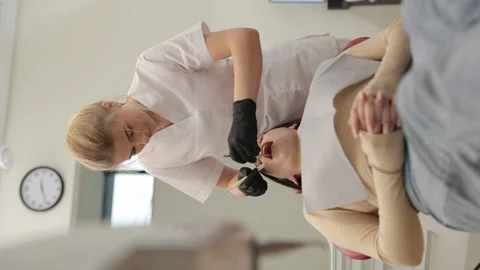 Female dentist performs a dental procedure on a patient in a modern clinic with Video stock 310349889