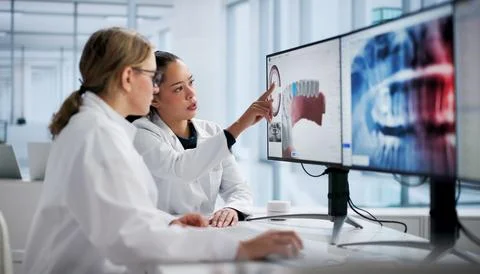 Female Dentist Using Computer To Screen For Dental Care Technology. Stock Photos