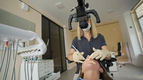 Female dentist using microscope during dental examination in clinic Stock Footage 336199244