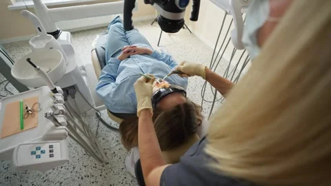 Female dentist using microscope during dental examination in clinic Stock Footage 336199434